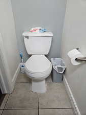 Bathroom with light tile patterned floors and a textured wall
