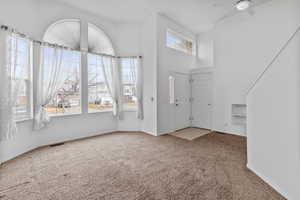 Inviting entryway with large windows, high vaulted ceilings