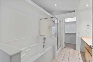 Primary bathroom with a walk in closet, separate shower and soaker tub