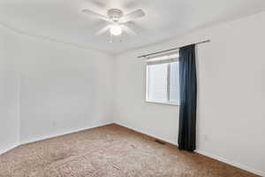 Bedroom 2 with walk-in closet, carpet, and a ceiling fan