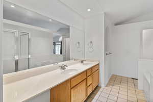 Primary, ensuite bath featuring dual sinks, a large vanity, tile floors, recessed lighting, and a separate shower