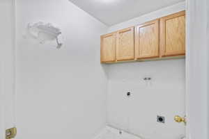 Laundry room convenient to upstairs bedrooms featuring hookup for a washing machine, cabinet space, a textured ceiling, electric dryer hookup, and electric dryer hookup