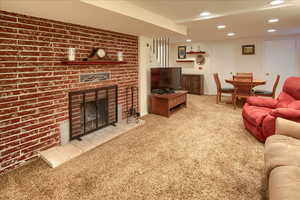 Living room with light carpet, a fireplace, and recessed lighting