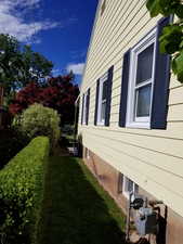 View of property exterior with a yard