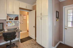 Home office with ornamental molding and light tile patterned floors