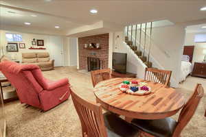Dining room with recessed lighting, a fireplace, and light colored carpet