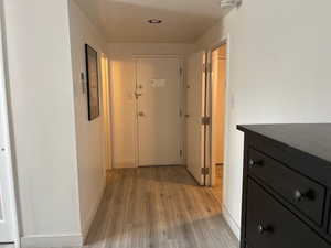 Lock out door in the hallway featuring light wood finished floors and baseboards