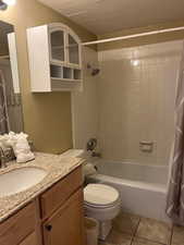 Bathroom featuring vanity, shower / tub combo, and light tile patterned floors