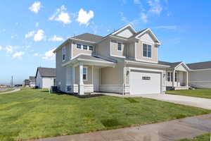 View of front of home featuring stone siding, an attached garage, a front yard, and concrete driveway