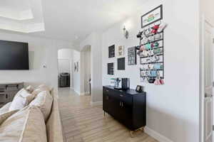 Living room with arched walkways, wood finish floors, and washer / clothes dryer