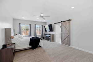 Bedroom featuring a barn door, light colored carpet, ceiling fan, and recessed lighting