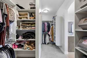 Walk in closet with light colored carpet