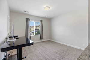 Unfurnished office featuring light carpet and baseboards