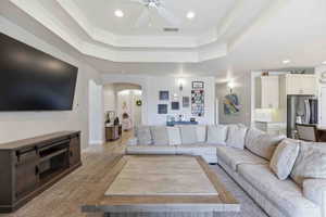 Living area with recessed lighting, arched walkways, and ceiling fan