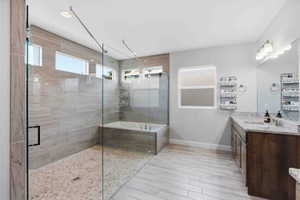Bathroom with vanity, a bath, a shower stall, and light wood finished floors