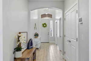 Foyer featuring wood tiled floors, arched walkways, and suspended lighting