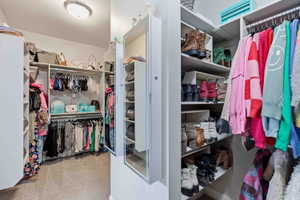 Walk in closet with light colored carpet
