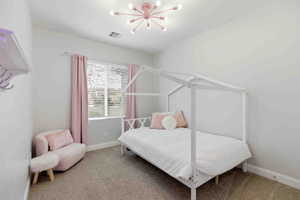 Carpeted bedroom with suspended lighting and baseboards