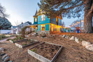 Back of property at dusk featuring a garden