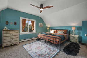 Bedroom with vaulted ceiling, a baseboard radiator, carpet floors, and ceiling fan