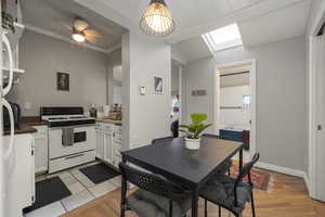 Dining space featuring a skylight, ceiling fan, and ornamental molding
