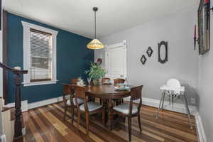 Dining space with hardwood / wood-style floors and a baseboard radiator