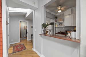 Corridor featuring light wood finished floors, ornamental molding, and baseboard heating