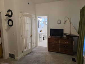 Main Floor Bedroom featuring light carpet and an Ensuite Bath
