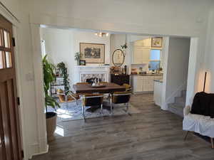 Dining space featuring dark wood finished floors, a chandelier, and a tile fireplace
