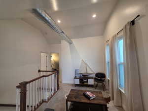 Loft with vaulted ceiling, an upstairs landing, recessed lighting, and light carpet