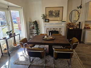 Dining area featuring dark wood finished floors and a fireplace