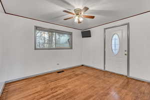 Foyer with light wood finished floors and ceiling fan