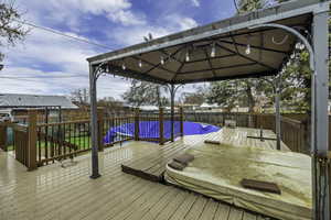 Wooden terrace featuring a gazebo and a fenced backyard