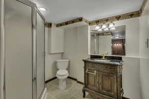 Full bath featuring vanity, a stall shower, and light tile patterned flooring