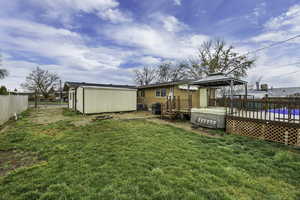 Back of property with a wooden deck, a gazebo, and a shed