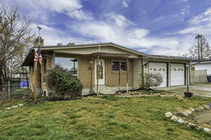 Single story home with an attached garage, brick siding, a chimney, and driveway
