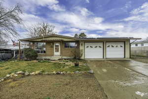 Ranch-style home with a garage, driveway, brick siding, and a porch