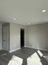 Unfurnished room featuring dark wood-type flooring and recessed lighting
