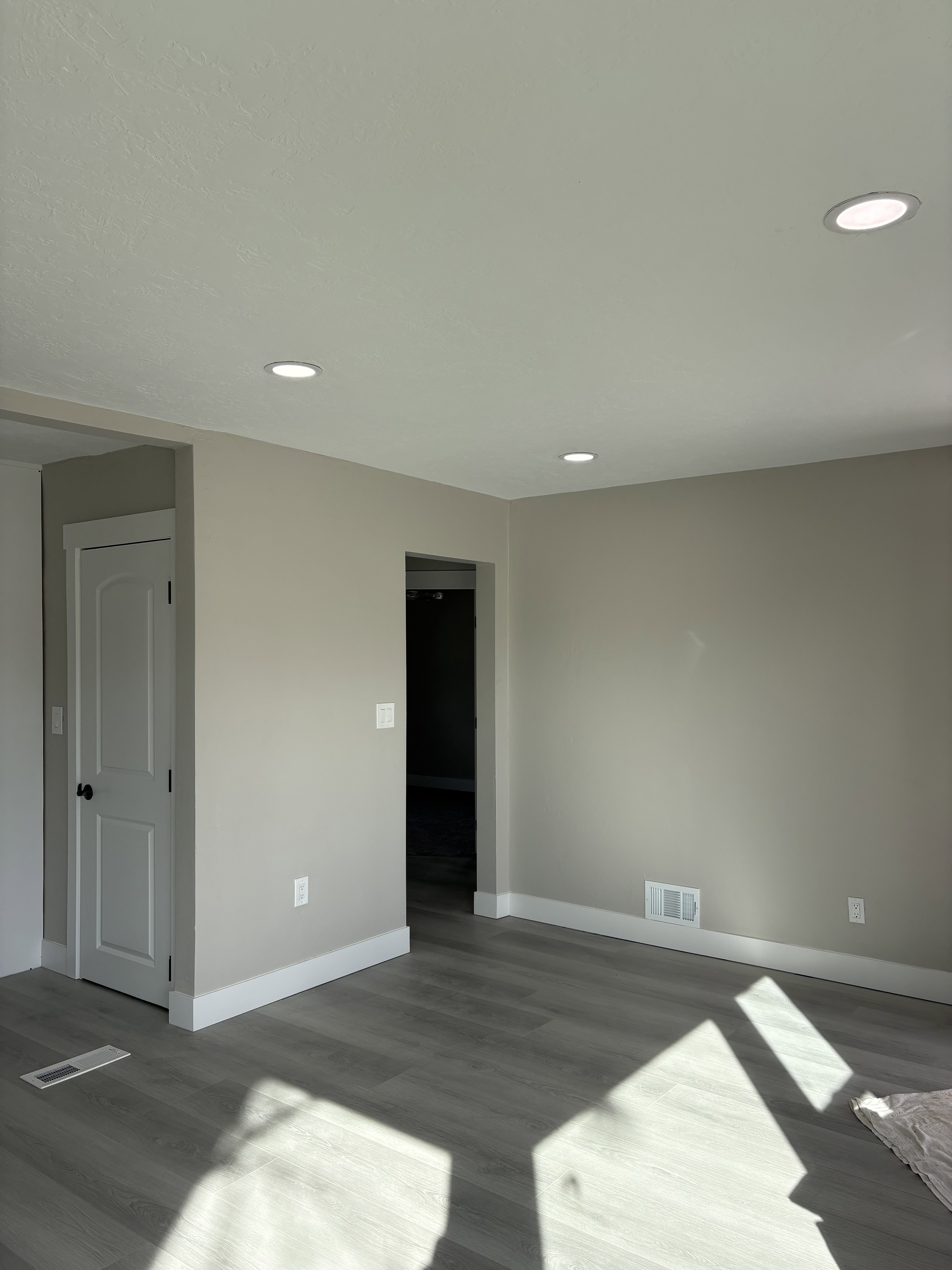 Living room featuring light laminate floors, a textured ceiling, and recessed lighting