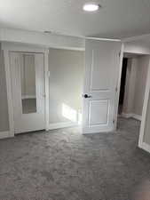 Unfurnished bedroom featuring a textured ceiling and carpet flooring