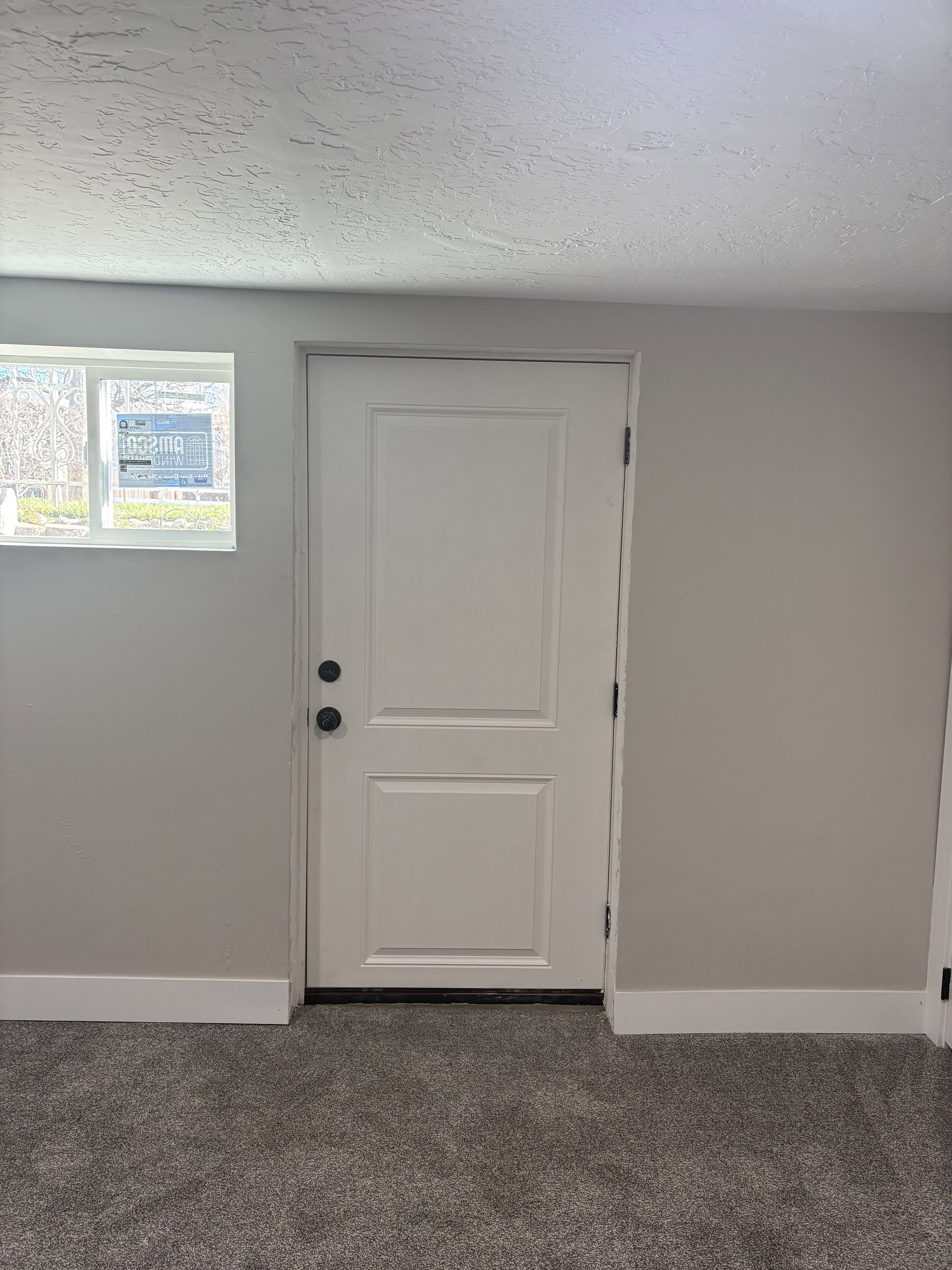 Bedroom 3 Doorway to outside light grey carpet floors and a textured ceiling
