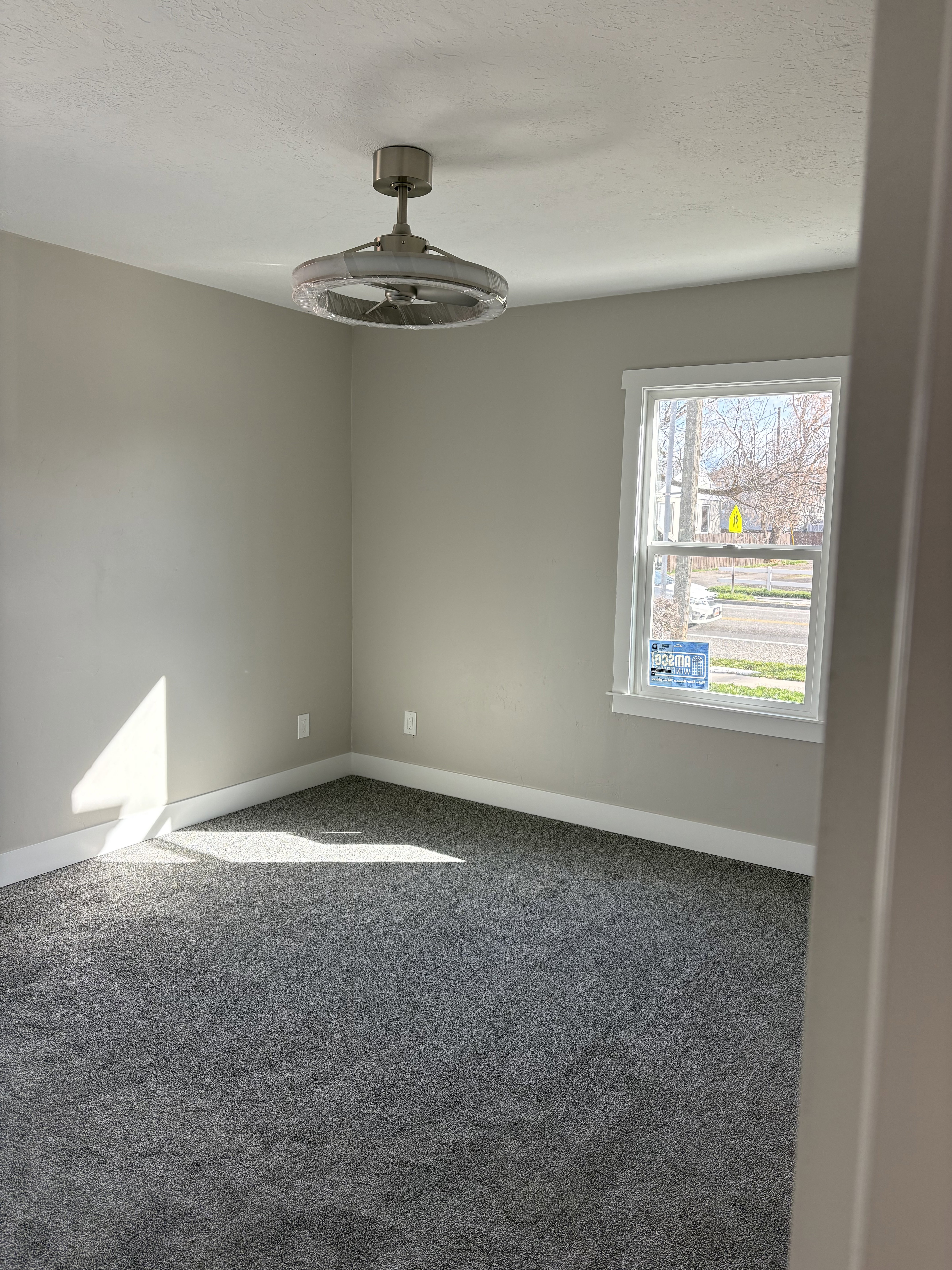 Bedroom 1 light colored carpet and a textured ceiling ceiling fan/light