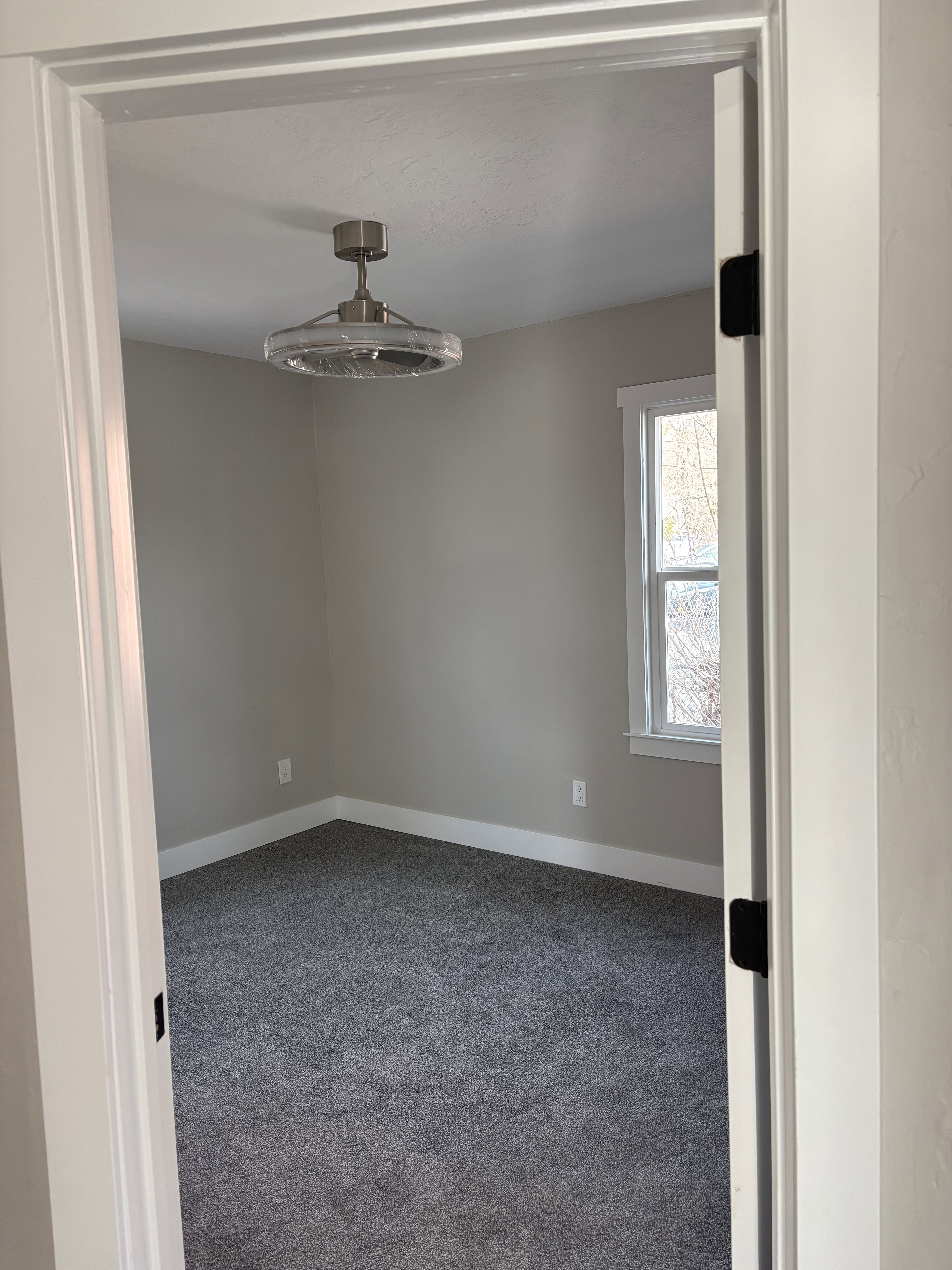 Bedroom 2 light colored carpet and a textured ceiling ceiling fan/light