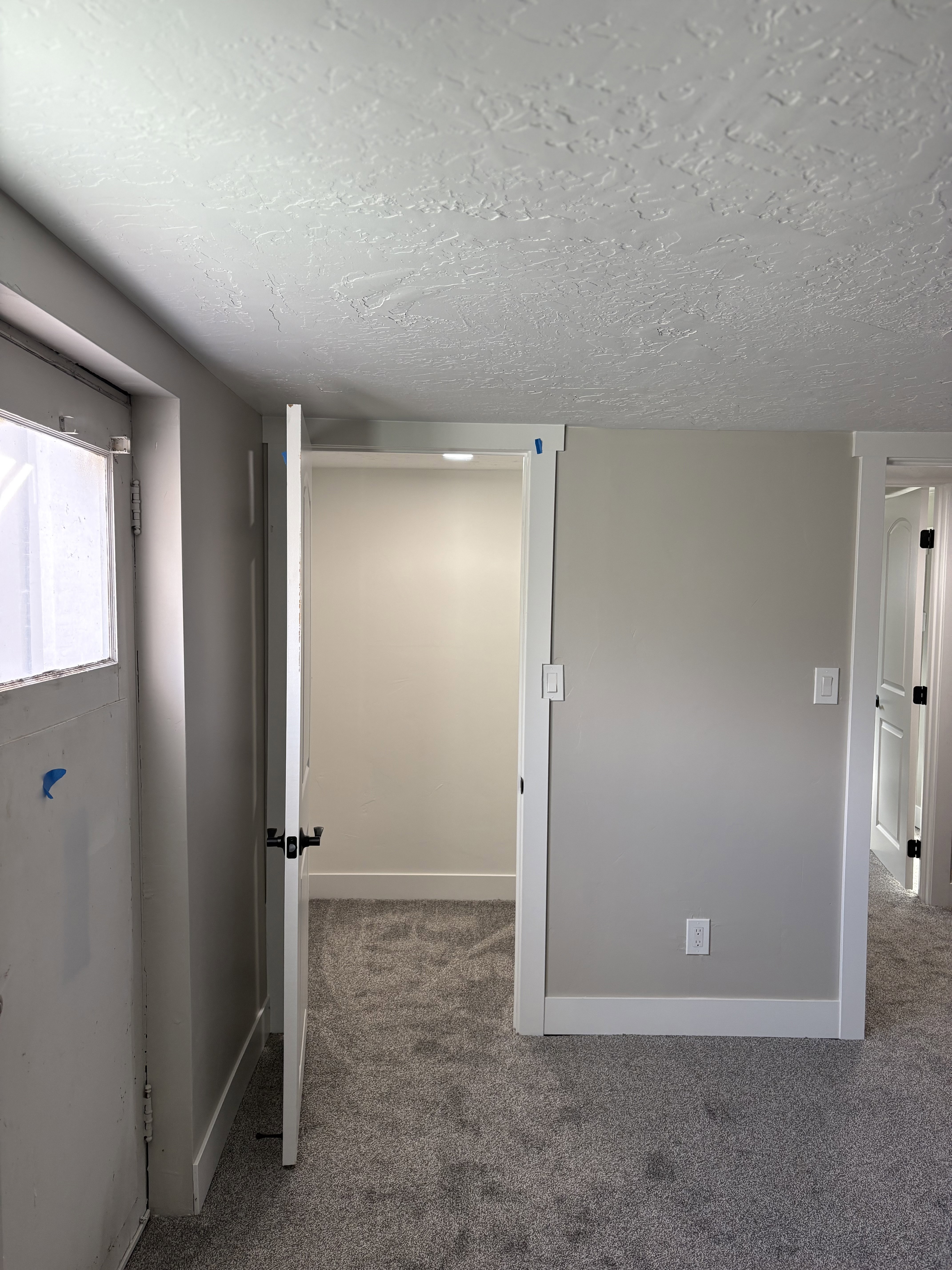 Bedroom 3 walk in closet light grey carpet floors and a textured ceiling
