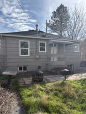 Rear view of property featuring a patio area and roof with shingles