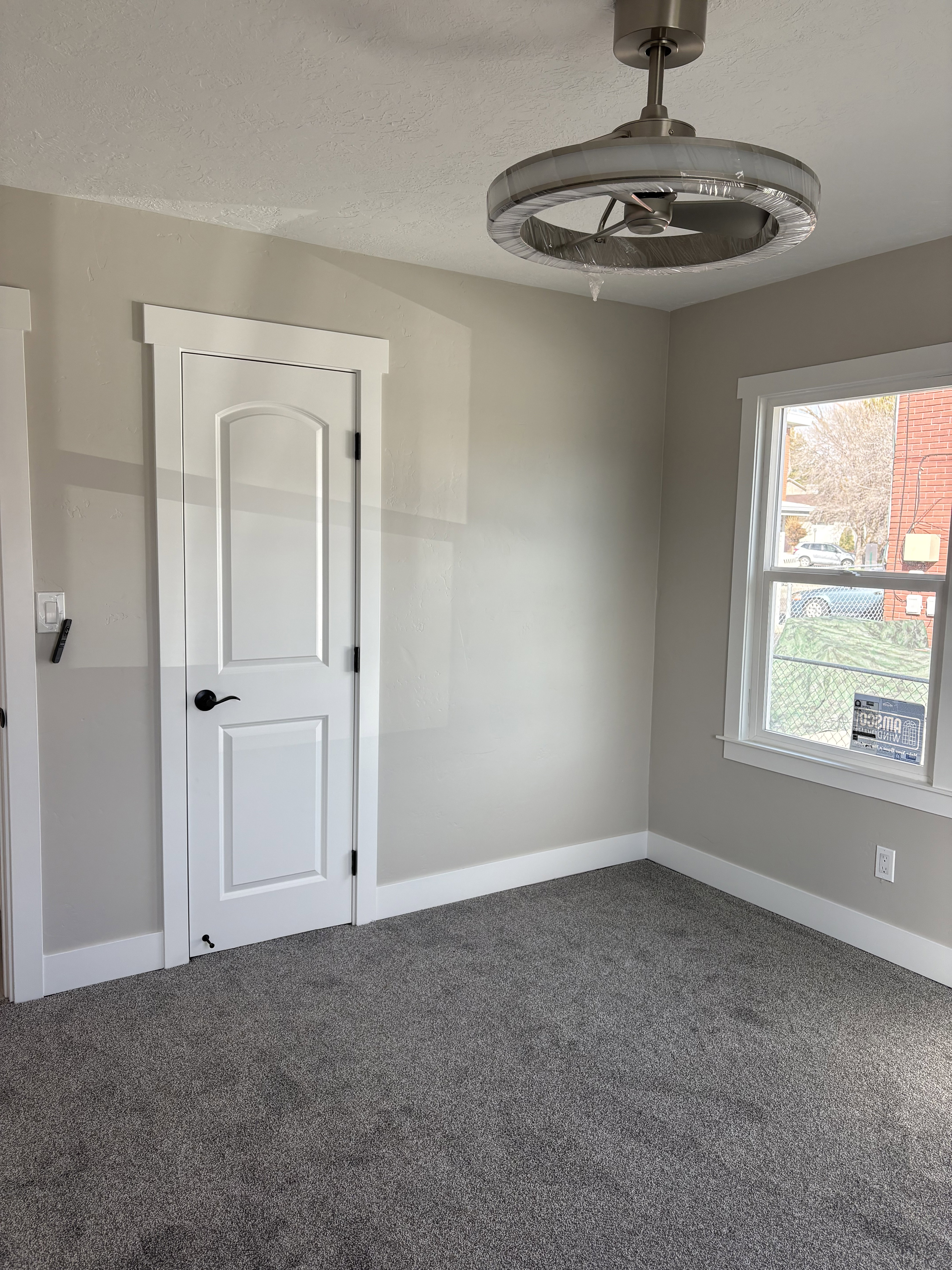 Bedroom 1 closet light colored carpet and a textured ceiling ceiling fan/light