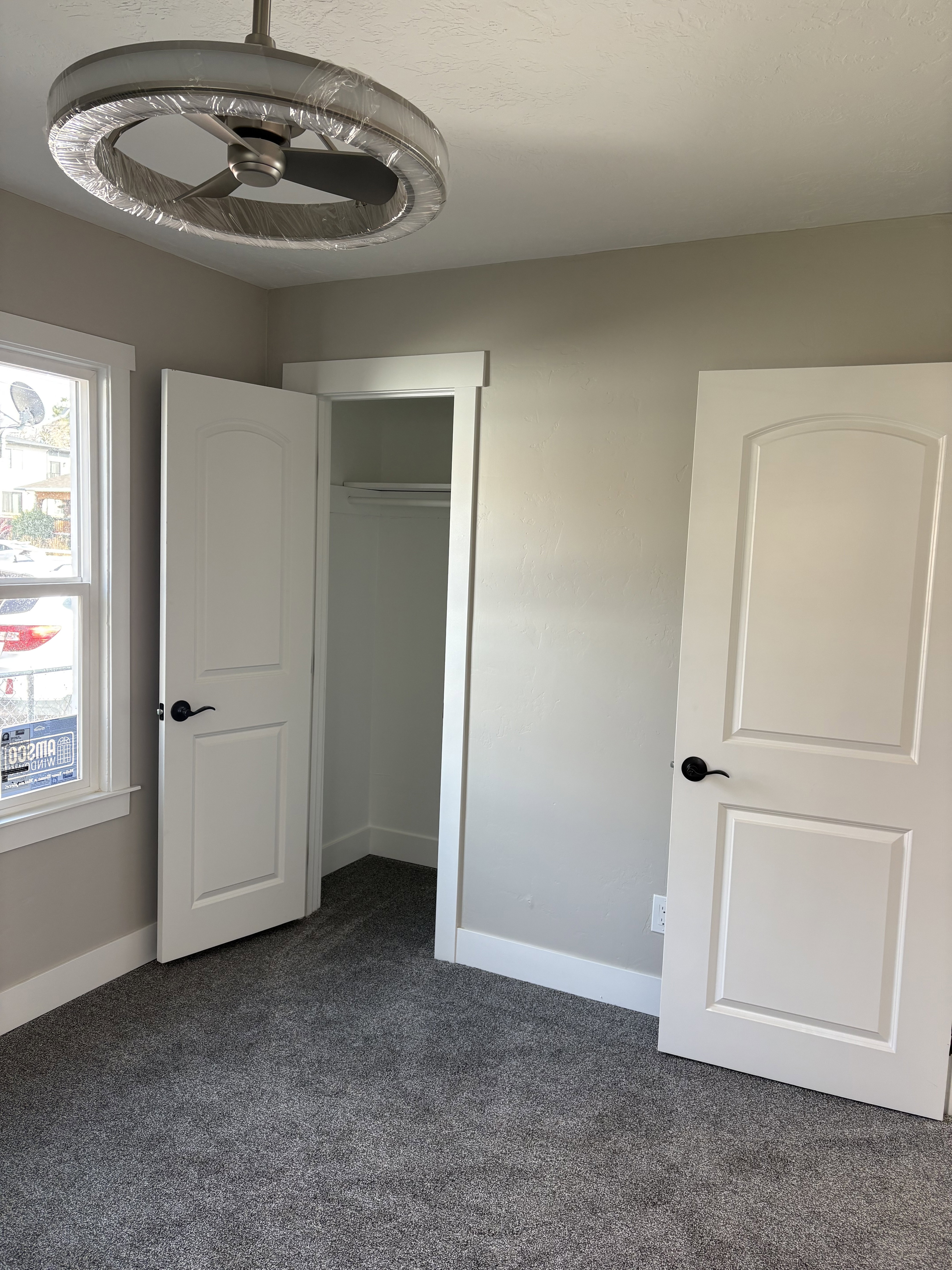 Bedroom 2 closet light colored carpet and a textured ceiling ceiling fan/light
