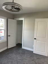 Unfurnished bedroom with dark carpet and a closet