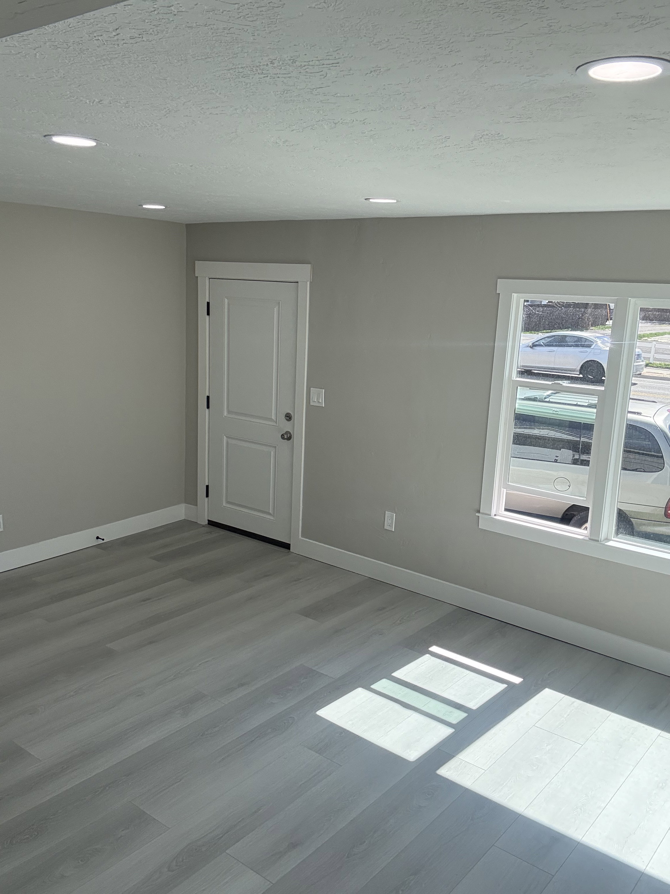 Front entry and living room featuring light laminate floors, a textured ceiling, and recessed lighting