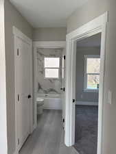 Bathroom with light wood finished floors and shower / tub combination